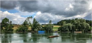 Fotokarte Rhein-Flusslandschaft bei Diessenhofen (Schweiz) mit Fischerboot und dramatischem Wolkenhimmel, Panoramaformat