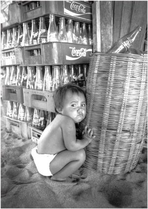 Fotokarte Kleinkind mit Coca-Cola-Kisten am Strand von Zipolite, Puerto Angel (Mexico), Schwarzweiss-Fotografie von 1990